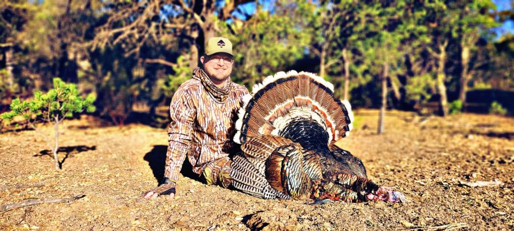 Hunter posed with a harvested Gould's turkey, full tail fan