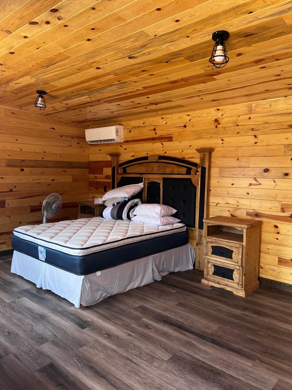 King bedroom — pine interior, mini-split, rustic nightstand