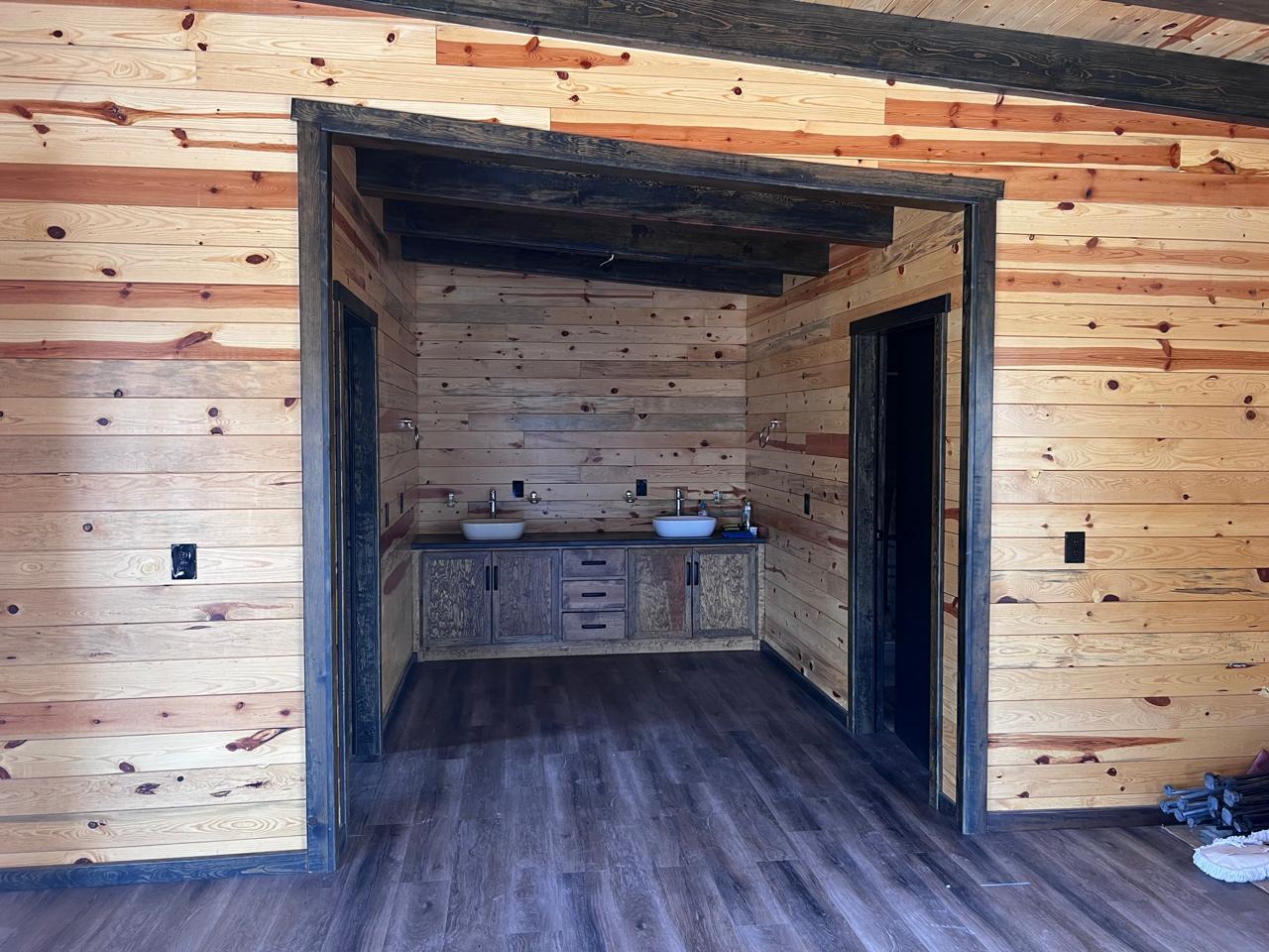 Double-sink bathroom — pine paneling and dark vanity