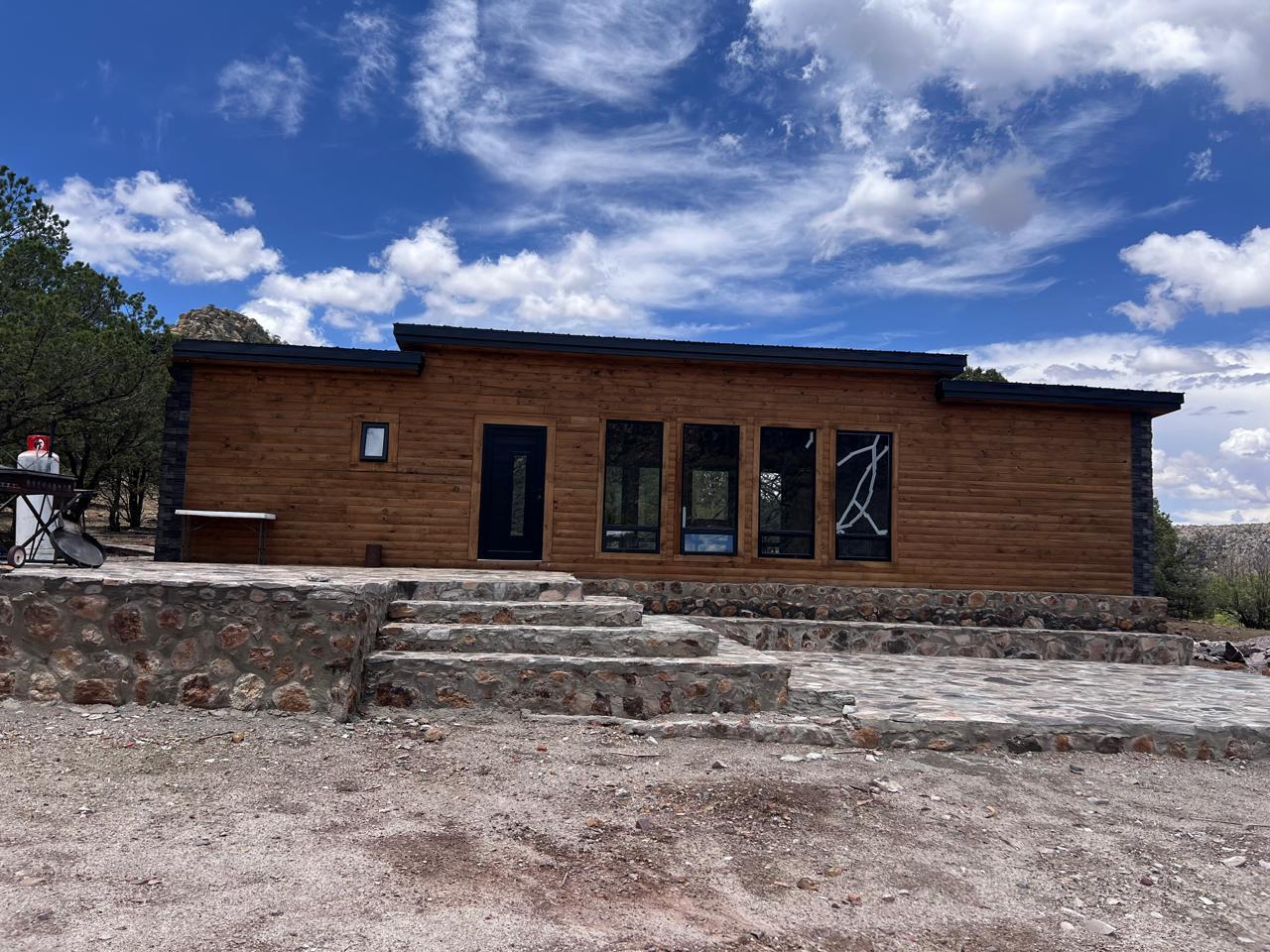 Cabin exterior — front view with big windows and stone steps